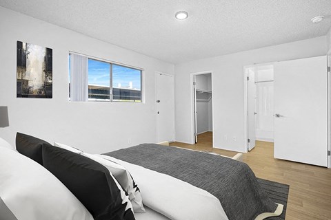 Furnished bedroom with wood floors, closet, and window