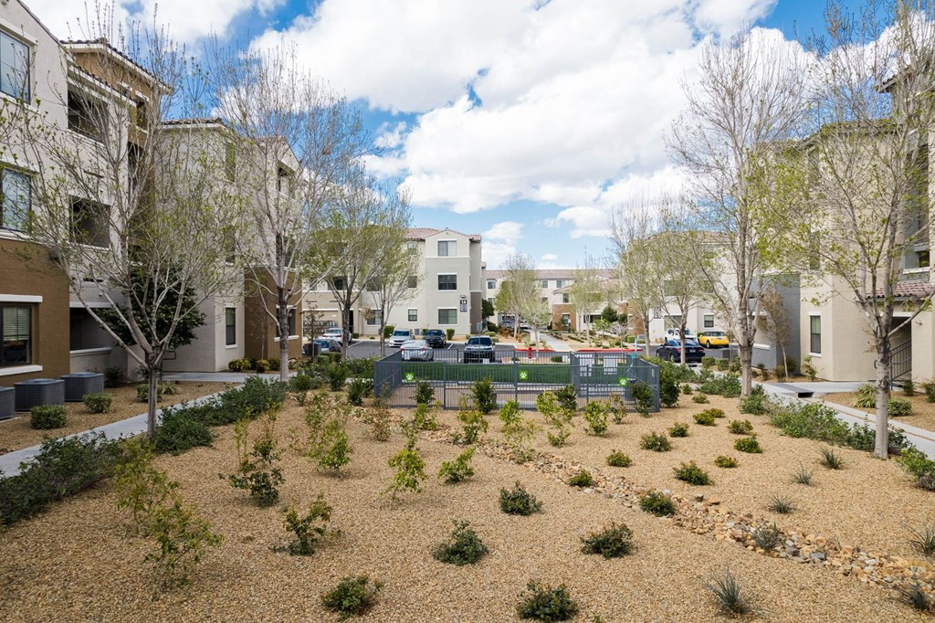 a courtyard with trees and plants in the middle of apartment buildings at CHANDLER APARTMENT HOMES, Las Vegas, Nevada