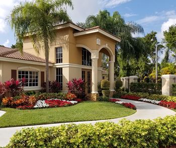 a home with a round driveway and palm trees at Hibiscus Pointe, Miami 