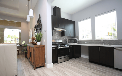 A modern kitchen with black cabinets and a wooden island.
