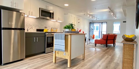 A modern kitchen with a refrigerator, oven, and microwave.