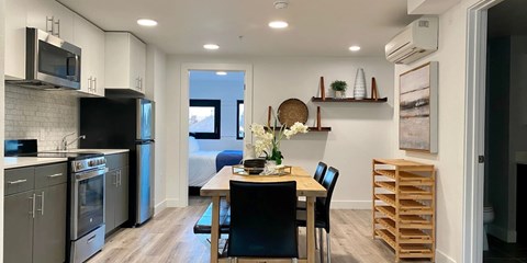 A kitchen with a table and chairs in the middle of it.