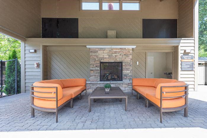 Ttwo orange couches and a fireplace