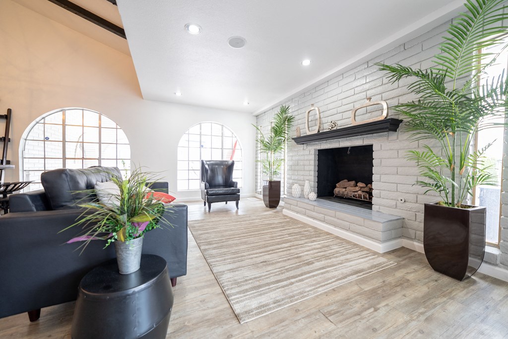 a living room with a white brick fireplace and wooden floors at DESERT PEAKS, EL PASO, 79912