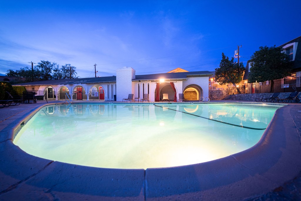 a large swimming pool in front of a building at night at DESERT PEAKS, EL PASO, 79912