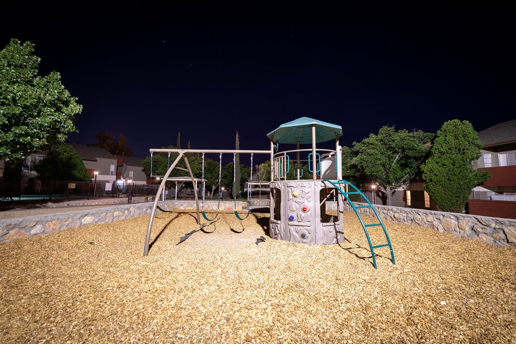 a swing set in a park at night at DESERT PEAKS, Texas, 79912