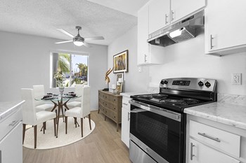 Dining and kitchen with stainless steel appliances and white cabinets - Photo Gallery 4