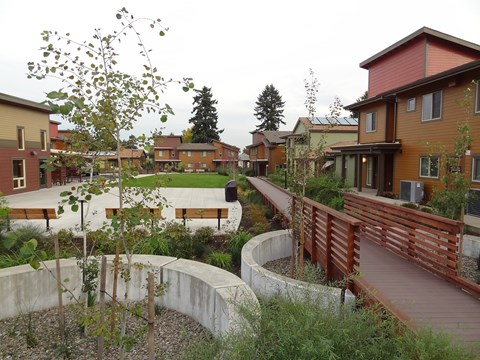 A view of a courtyard with a bridge and a building in the background.