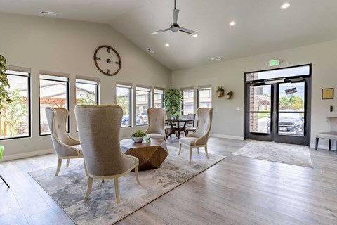 a living room with a table and chairs and a clock on the wall