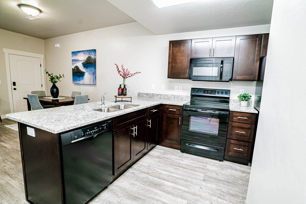 a kitchen with stainless steel appliances and a counter top a kitchen with stainless steel appliances and a counter top at Arcadia Townhomes, Roy, UT 84067