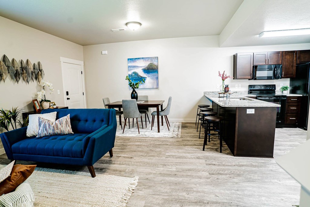 a living room and kitchen with a blue couch at Arcadia Townhomes, Utah, 84067