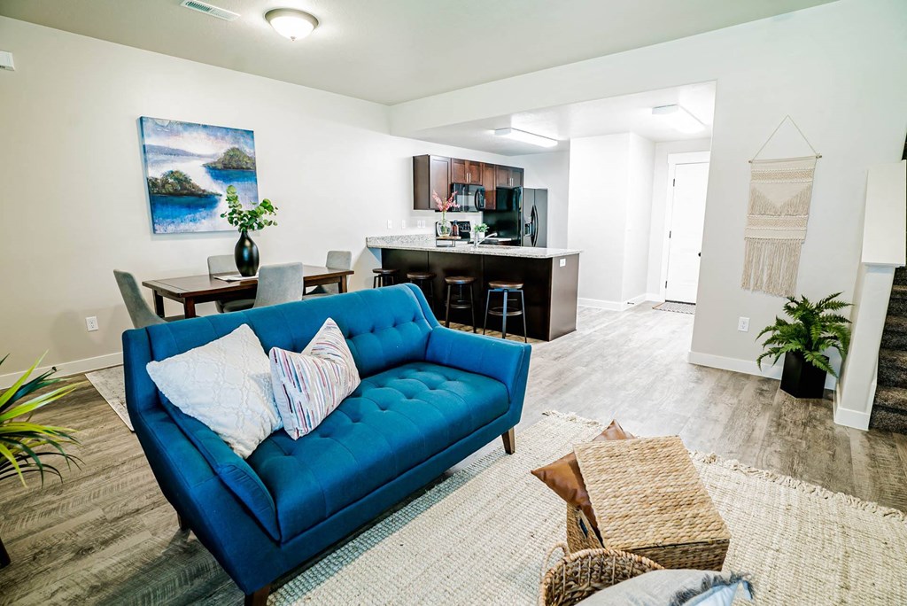 a living room and kitchen with a blue couch at Arcadia Townhomes, Utah