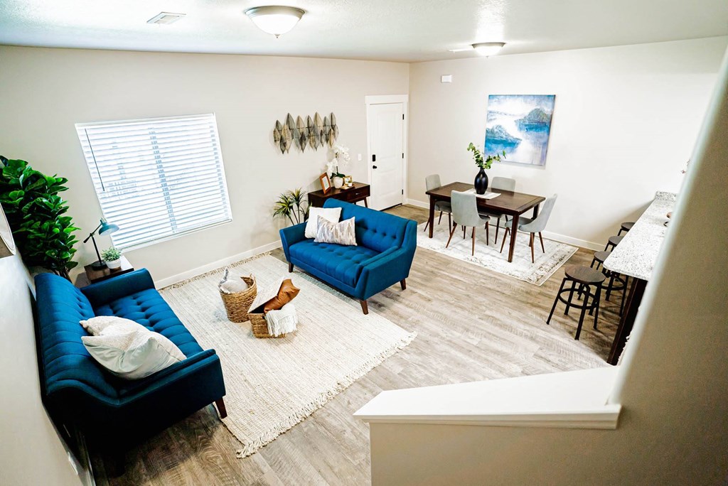 an aerial view of a living room and dining room with blue furniture at Arcadia Townhomes, Roy, UT 84067