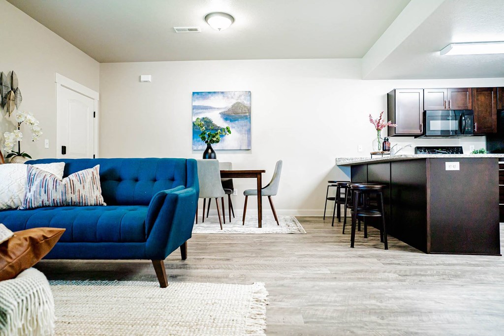 a living room and kitchen with a blue couch at Arcadia Townhomes, Roy, 84067