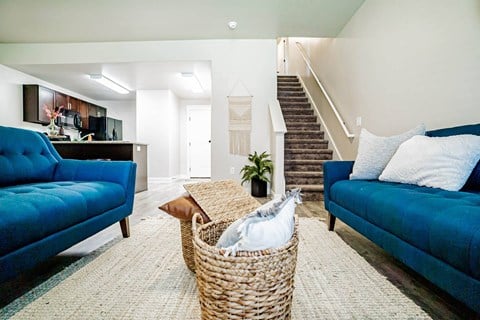 a living room with two blue couches and a basket