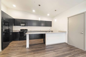 Crescent Point kitchen with plank flooring and dark cabinetry and appliances - Photo Gallery 5