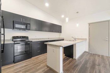 Crescent Point kitchen with plank flooring and dark cabinetry and appliances - Photo Gallery 2