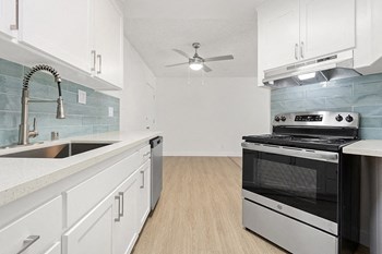 Kitchen with stove and tile backsplash l Nimitz Pointe Apartments - Photo Gallery 3