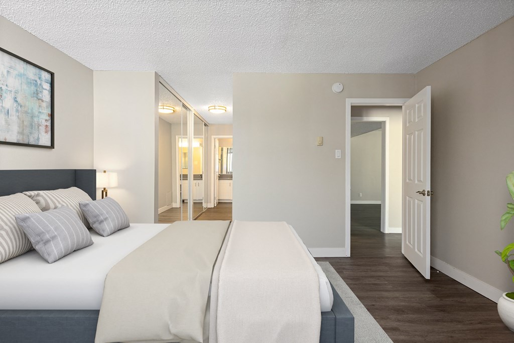 a bedroom with a large white bed and a large mirror on the wall