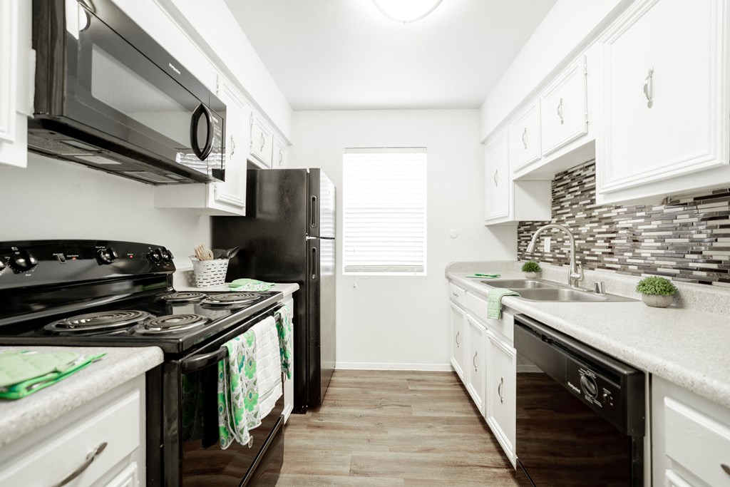 a kitchen with white cabinets and black appliances at DESERT PEAKS, EL PASO Texas