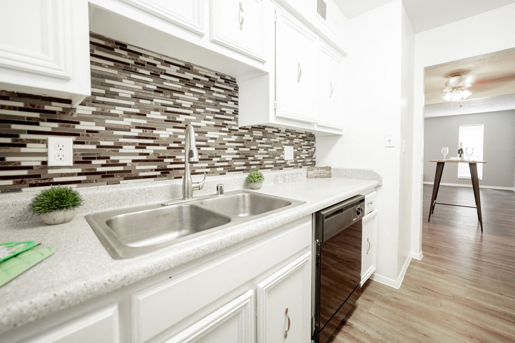 a kitchen with white cabinets and a stainless steel sink a kitchen with white cabinets and a stainless steel sink at DESERT PEAKS, EL PASO, 79912