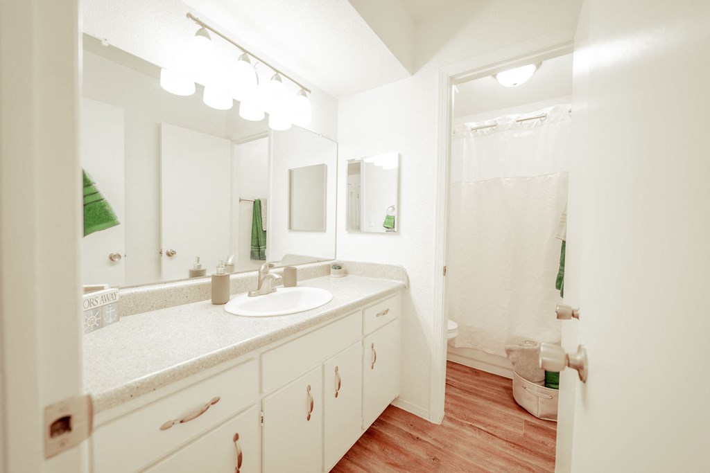 a bathroom with white cabinets and a white shower curtain a bathroom with white cabinets and a white shower curtain at DESERT PEAKS, EL PASO, Texas