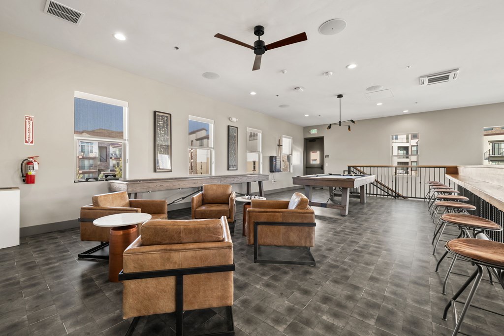 A spacious waiting area with brown leather chairs and tables.