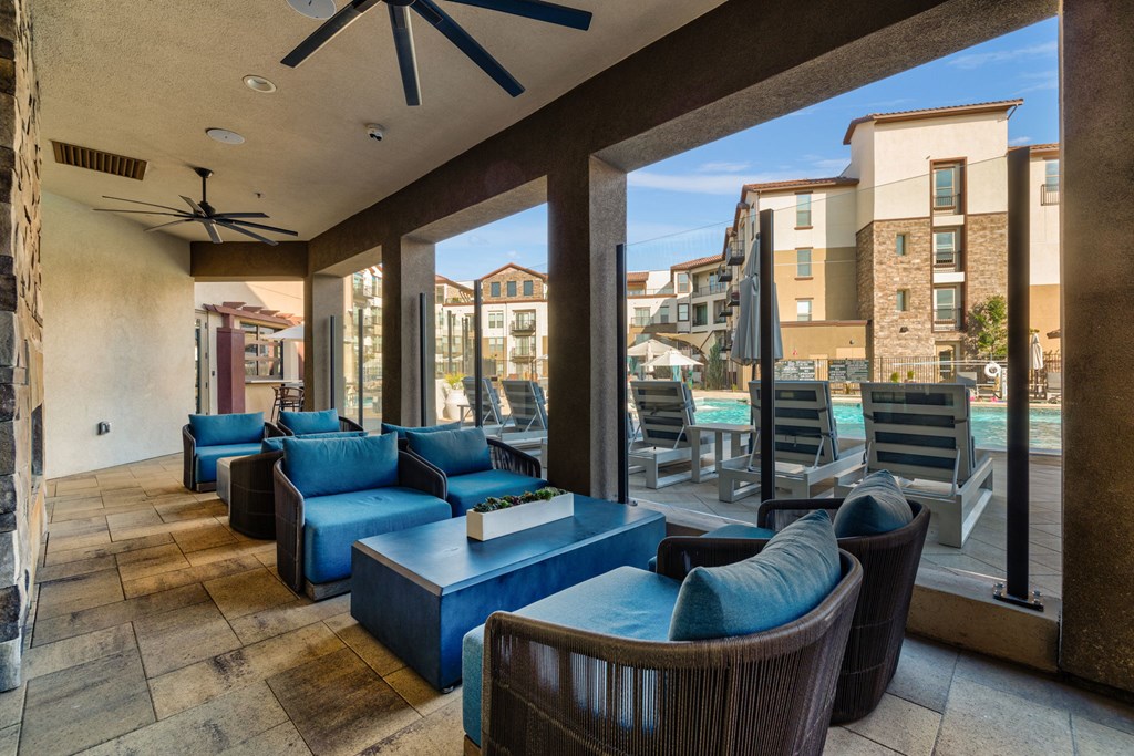 A patio with a blue couch and chairs.
