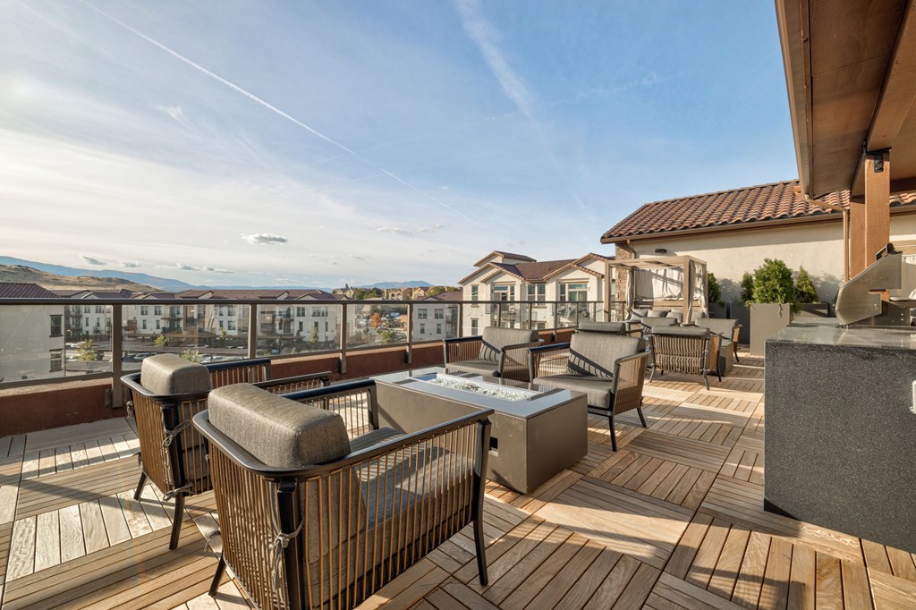 A patio with a hot tub and chairs overlooks a residential area.