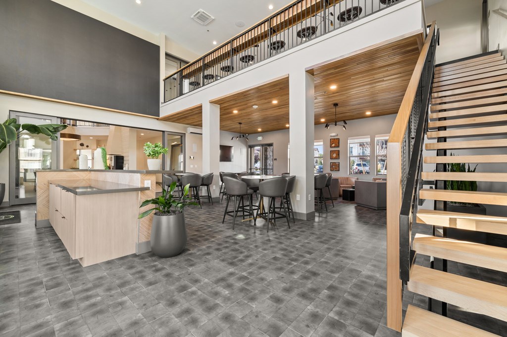 A spacious interior of a building with a bar area and a staircase.