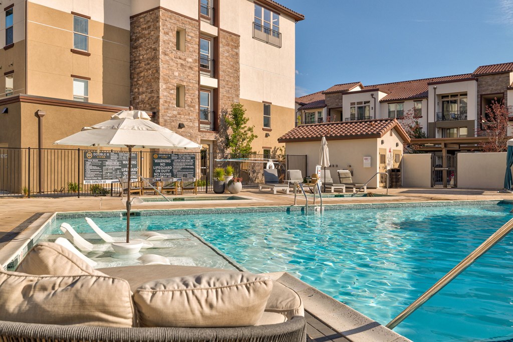 A pool with a hot tub in front of a building.