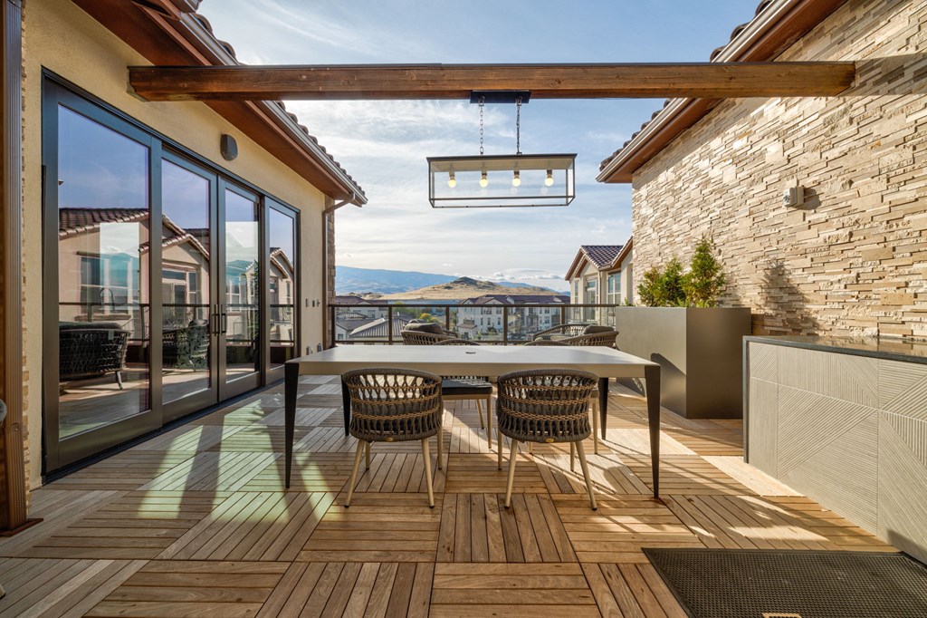 A patio with a table and chairs overlooking a body of water.