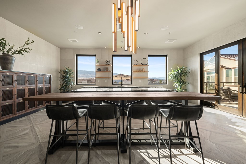A modern dining room with a long table and chairs.