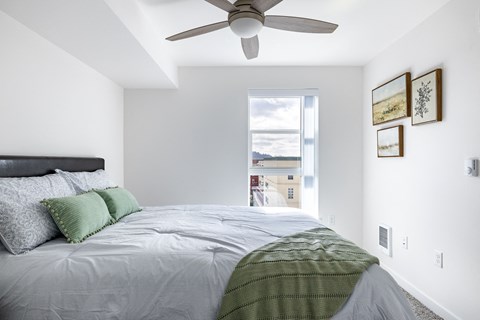 A bedroom with a large bed and a ceiling fan.at Traditions at Hazelwood, Portland