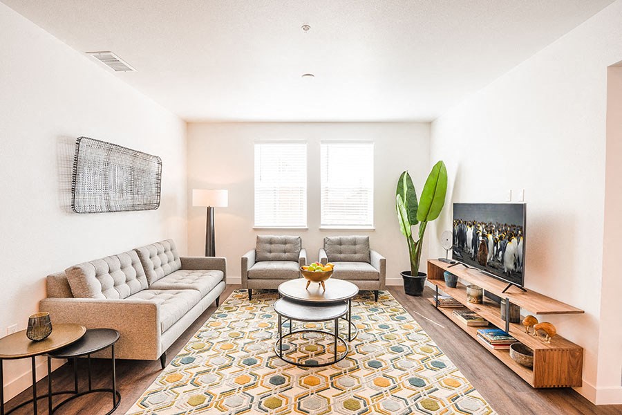 Chico Apartments - Living Room With High Ceiling, Plank Flooring, And Two Windows With Blinds.