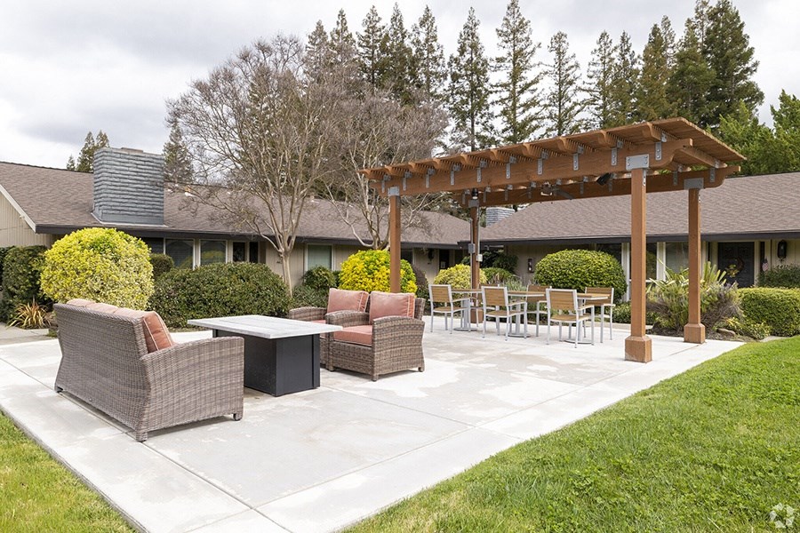 a patio with a table and chairs and a pergola