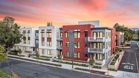 an aerial view of an apartment complex with a sunset in the background
