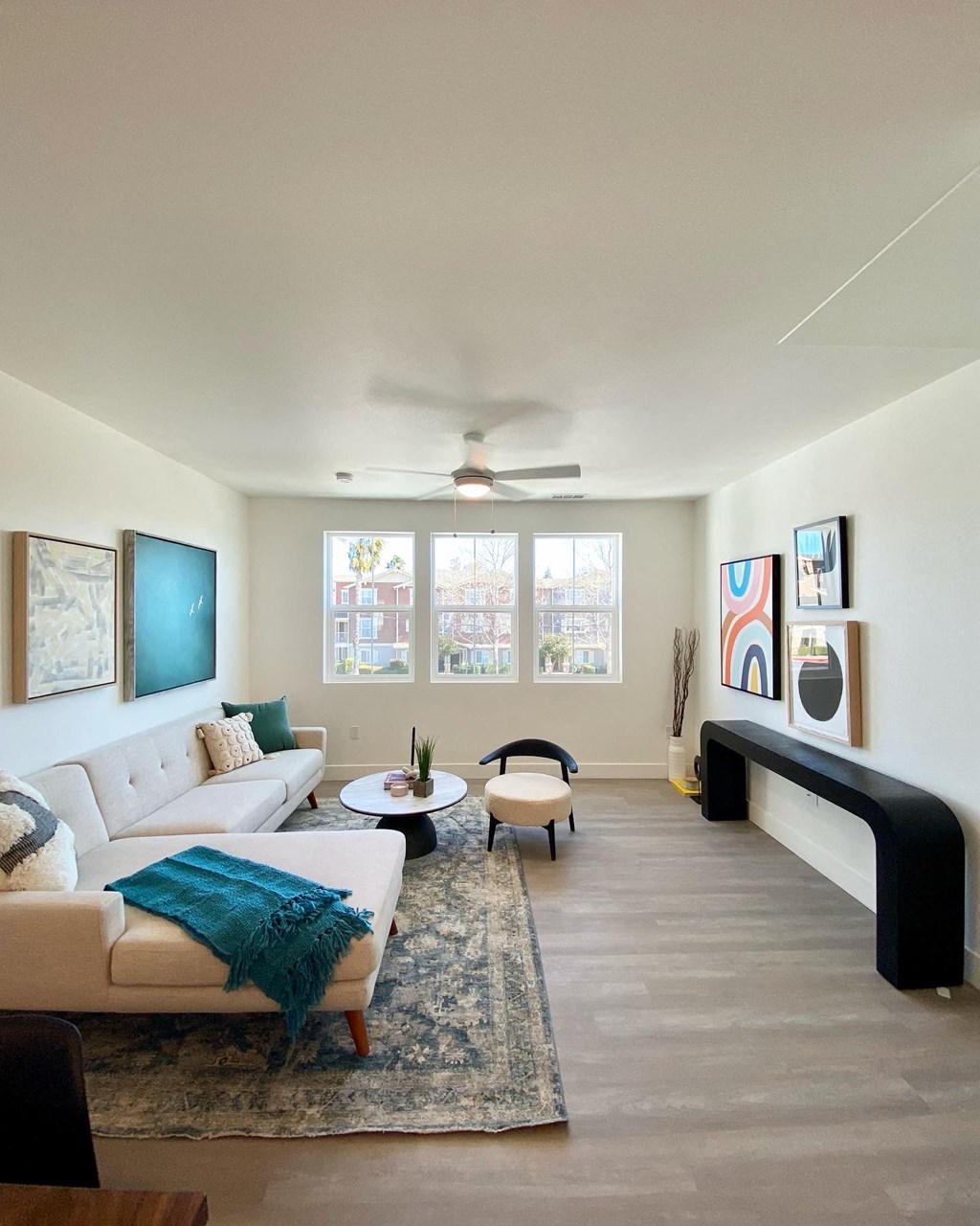 a living room with a white couch and a ceiling fan