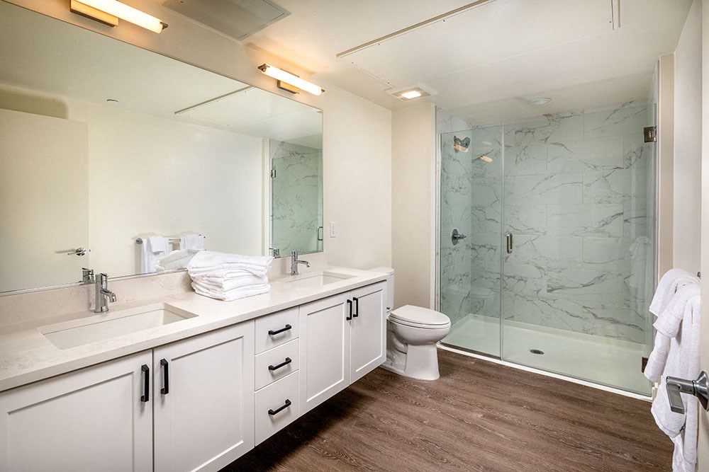 Main bathroom with large vanity and shower 