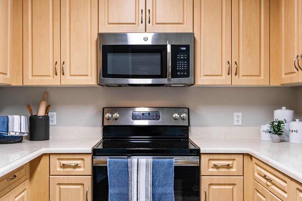 a kitchen with wooden cabinets and a black stove top oven at K Street Flats, Berkeley, CA