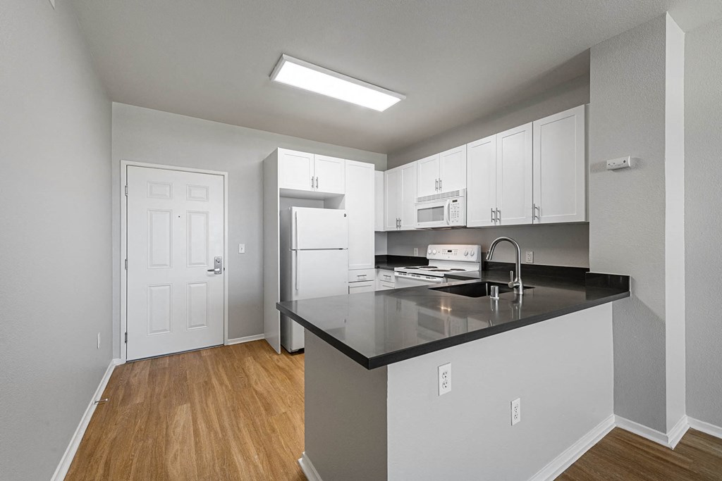 a kitchen with white cabinets and a black counter top a kitchen with white cabinets and a black counter top at K Street Flats, Berkeley, 94704