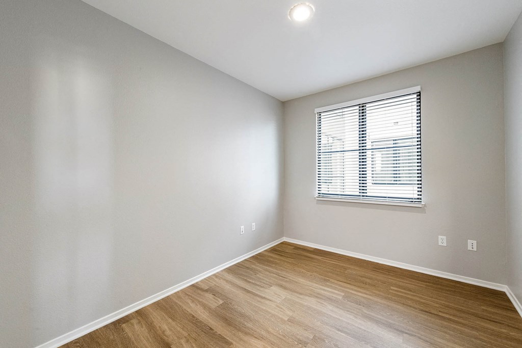 a bedroom with hardwood floors and a window at K Street Flats, Berkeley California