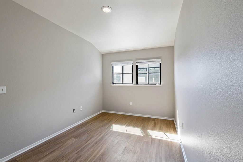 a bedroom with hardwood flooring and two windows at K Street Flats, Berkeley, 94704
