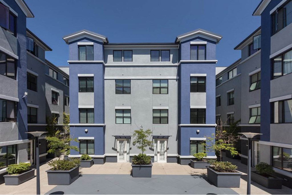 a blue and white building with potted plants in front of it at K Street Flats, Berkeley, 94704