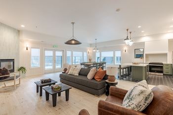 A living room with a grey couch and a brown leather chair at FALLS CREEK APARTMENTS, Coeur DAlene, ID