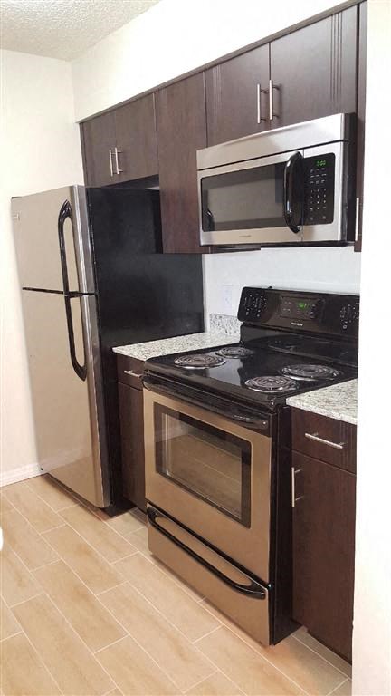 The Edge at Town Center kitchen with dark cabinets and stainless steel appliances