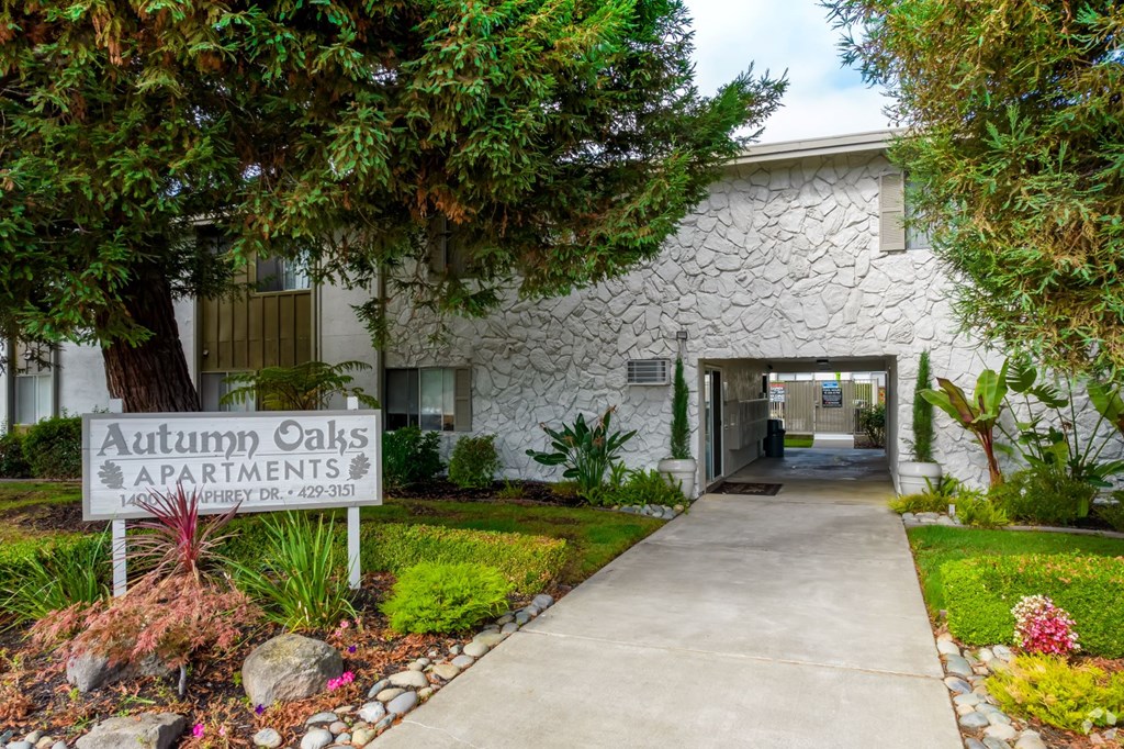a white building with a sign for autumn oaks apartments