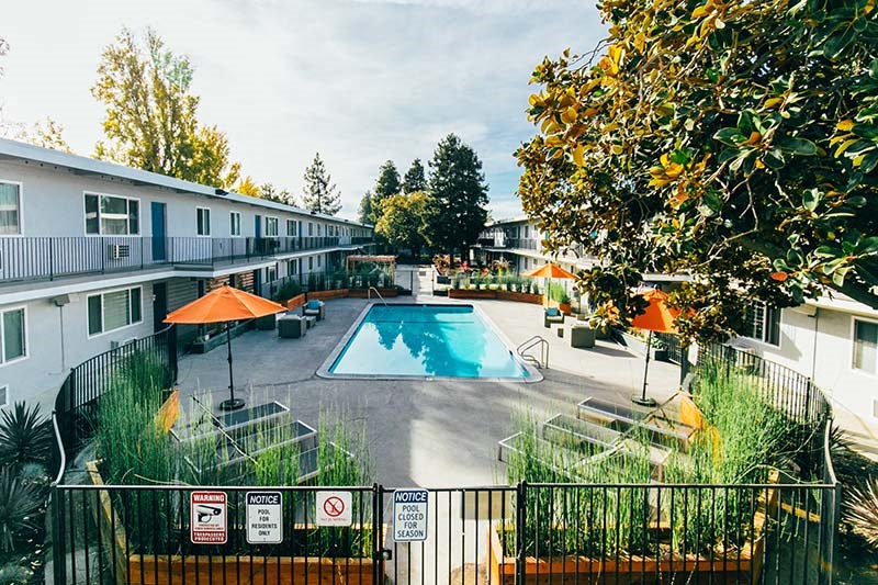 Apartments For Rent In Fairfield, CA - Magnolia Terrace - An Aerial View Of The Fenced-In Pool Area With Lounge Chairs And Umbrellas