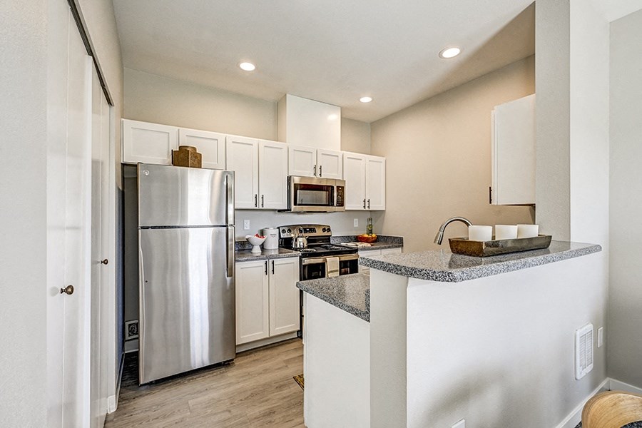 Kitchen with Granite-Style Countertops, Stainless-Steel Appliances, and Bar at BELLA SONOMA, Fife 