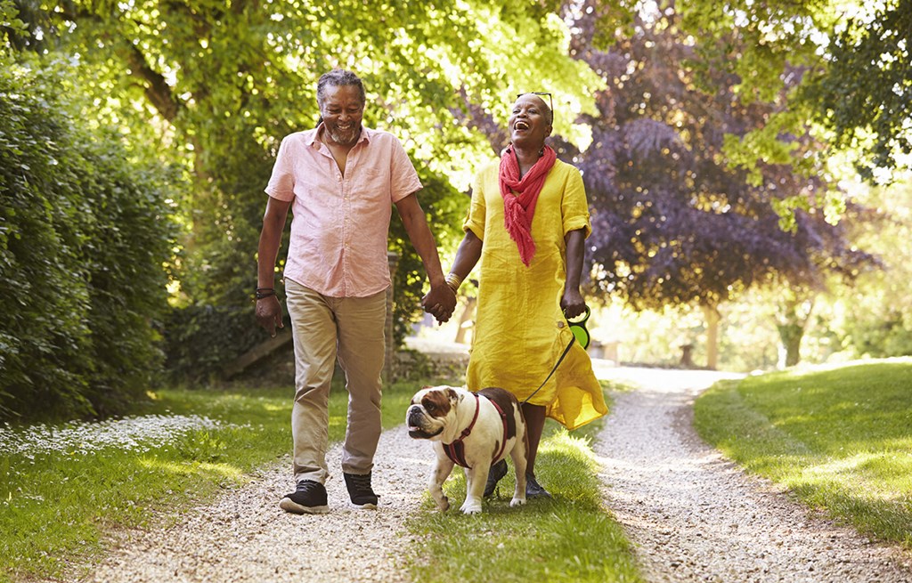 Senior couple walking their dog outside